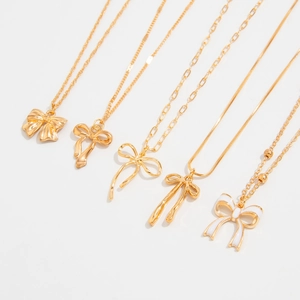 Détails de cinq colliers pendentifs nœuds avec finition émail et divers styles de chaînes