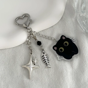 Détail du fermoir en cœur avec pendentifs chat noir, arête de poisson et étoile