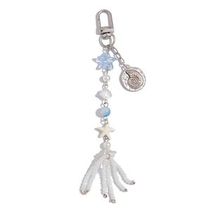Detailed shot of ocean-style charm with blue stars, pearls, and shell beads with tassels