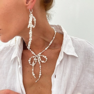 Elegant pearl jewelry set featuring bow-knot necklace and matching tassel earrings