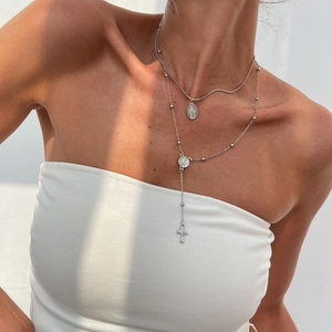 Ensemble de colliers superposés argentés avec médaille Marie et croix en strass sur mannequin
