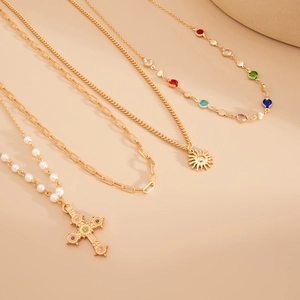 Détail du lot de 4 colliers dorés avec pendentif croix et breloques en cristal coloré