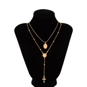 Détail du collier religieux doré à double rangée avec médailles Vierge Marie et croix