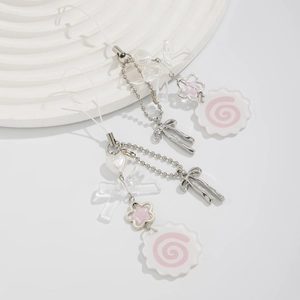 Detail of butterfly and heart pendant keychain set on a minimalist white display