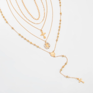 Détail du collier doré multicouche avec pendentif croix et médaille Vierge Marie