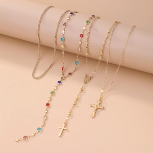 Détails des colliers dorés avec croix en cristal et pierres précieuses colorées