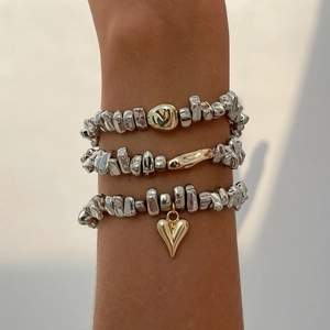 Nahaufnahme von dreiteiligem Armband-Set mit unregelmäßigen Silberperlen und Herzanhängern