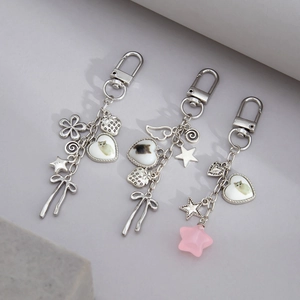 Close-up of silver cat-themed keychains with heart pendants and decorative star charms