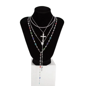 Détail d'un collier en Y argenté à plusieurs rangs avec perles colorées et crucifix