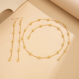 Detailed close-up of a golden Y-shaped beaded necklace and long matching earrings set