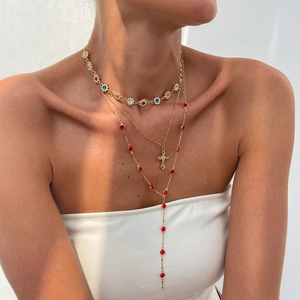 Ensemble de trois colliers dorés avec cristaux colorés et un pendentif en forme de croix