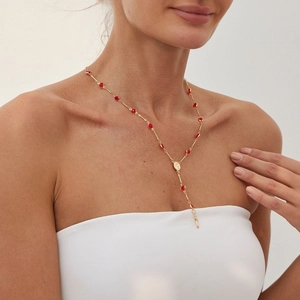 Détail du collier chapelet en Y avec perles en cristal rouge et croix dorée