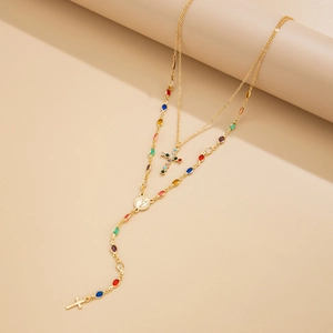 Détail du collier à deux rangs en or avec croix, perles colorées et médaille religieuse