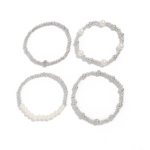 Makroaufnahme der 4-teiligen Silberperlen-Armband-Set mit weißen Perlen und Kreuz