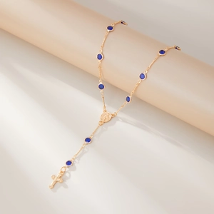 Détail du collier en Y plaqué or avec cristaux facettés bleu foncé et pendentif croix
