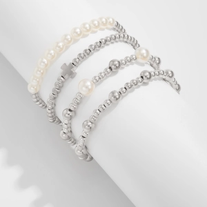 Detail eines vierteiligen Armband-Sets mit Silberperlen, Perlen und Kreuzanhänger