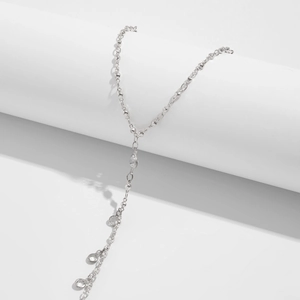 Silver Y-necklace detail with round metal links and hanging clear crystal pendants