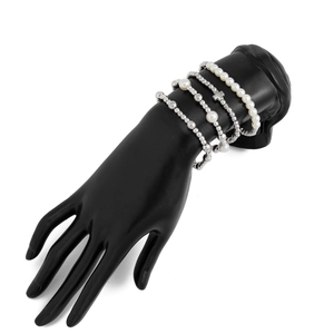Detailansicht eines mehrlagigen Perlenarmband-Sets mit Kreuzanhänger auf schwarzem Modell