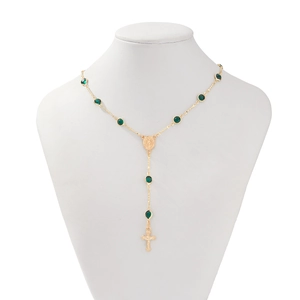 Détail du collier chapelet doré avec pierres vertes, médaille sacrée et croix jésus