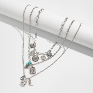 Detail view of multi-layered silver necklaces with turquoise beads and western charms