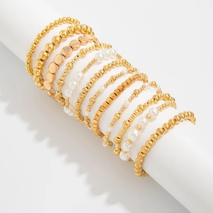 Minimalistisches goldfarbenes Perlenarmband-Set auf weißem Display-Ständer