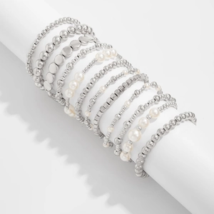 Detailansicht mehrlagiger Silberperlenarmbänder mit Metallanhängern und Kunstperlen
