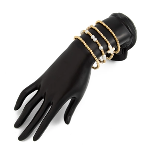 Detail eines mehrlagigen Gold-Perlenarmband-Sets mit Kreuzanhänger auf Display