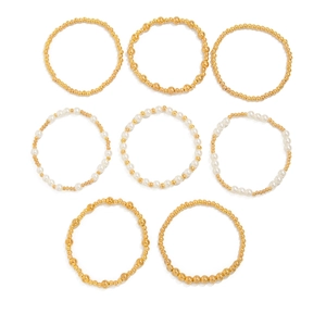 Detail von 8-teiligem Set aus Goldperlen und Kunstperlen-Armbändern auf weißem Grund