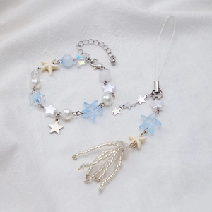 Detailed close-up of blue and white starfish charm bracelet with faux pearl beads