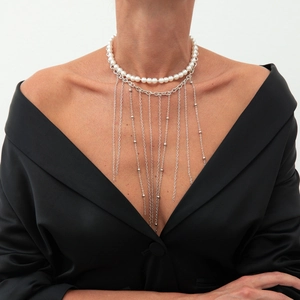 Detail einer mehrlagigen Perlenhalskette mit silbernen Quasten für Damen auf Model