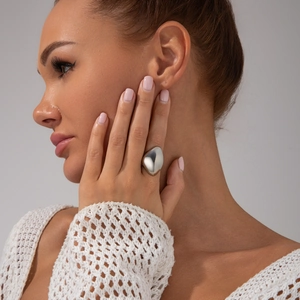 Gros plan d'une bague goutte en métal argenté poli sur la main d'une femme moderne