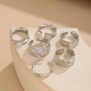Detailed view of silver liquid metal rings with lava texture on stone display