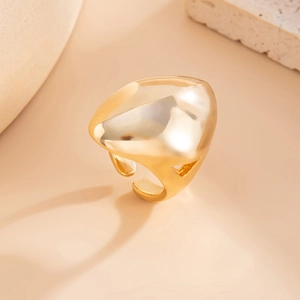 Gros plan de la bague dorée irrégulière avec finition miroir polie sur une pierre