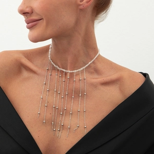 Detailansicht eines silbernen Chokers mit langen Metallquasten auf einem Model