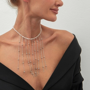 Detail eines silbernen Chokers mit Klarsichtperlen und hängenden Metallfransen