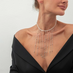 Detail der Quasten-Choker-Halskette mit Metallketten und Perlen am Modelhals