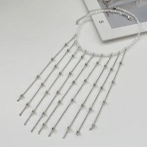 Detailaufnahme der Kette mit Metallquasten, klaren Perlen und silberfarbenem Fransen-Design