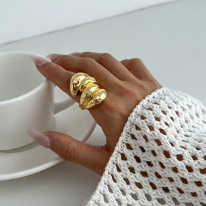 Gros plan d'une bague dorée irrégulière et épaisse avec une texture froissée brillante