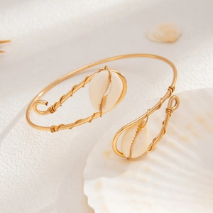 Macro shot of gold wire-wrapped bracelet with sea shell details and ocean vibes