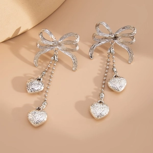 Boucles d'oreilles nœud argenté avec pendentifs cœur et longs glands perlés