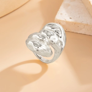 Détail d'une bague en métal argenté martelé avec surface irrégulière et design contemporain