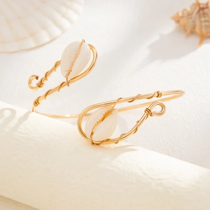 Gold wire wrapped upper arm cuff with shell accents for a bohemian ocean holiday style