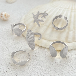 Detailed view of silver ocean-themed ring set with starfish and seashell charms
