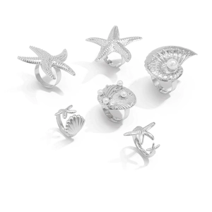 Detailed view of 6-piece silver starfish and shell rings with pearls and textures