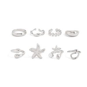 Detail of 8-piece silver metal ring set featuring starfish, shell, and wavy textures