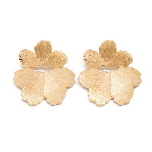 Dettaglio di orecchini floreali dorati con petali metallici dalla superficie goffrata