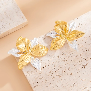 Dettaglio degli orecchini a fiore martellato con petali plissettati in oro e argento