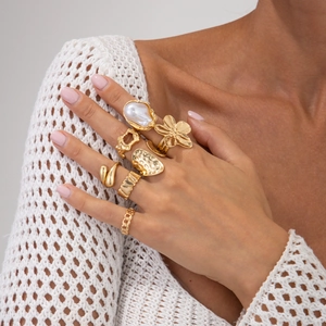 Detail von 7tlg. Goldring-Set mit Barockperle und Blumendesign an der Modelhand