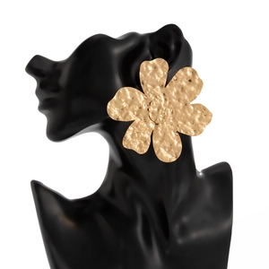 Dettaglio della collana con fiore dorato martellato con trama metallica su manichino nero