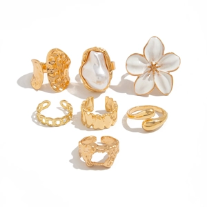 7-delige gouden ringenset met witte emaille bloem en imitatieparel accenten
